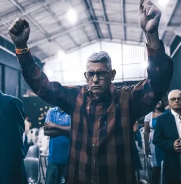Presidente da CMEBE em louvor, com as mãos levantadas, durante a celebração